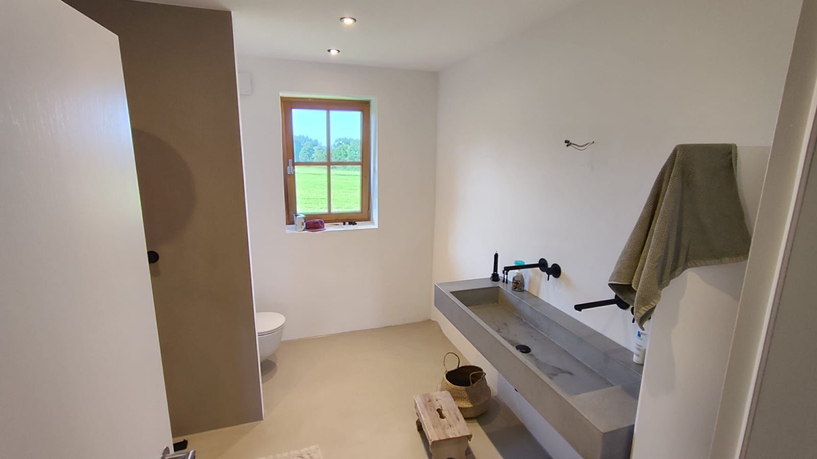Minimalistisches Bad mit Mikrozement in Sandbeige und Beton-Waschtisch