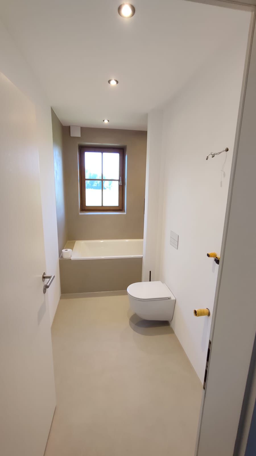 Bad mit eingelassener Wanne und Mikrozement in warmem Sandbeige
