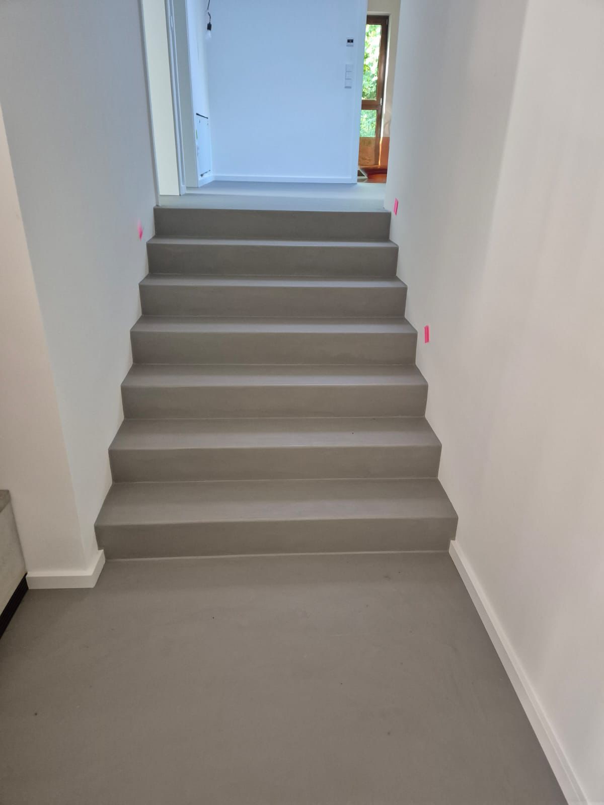 Durchgehende Mikrozement-Treppe in Hellgrau – nahtloses Bodendesign