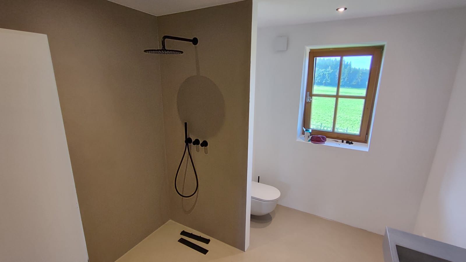 Walk-in-Dusche mit fugenlosem Mikrozement in warmem Sandton