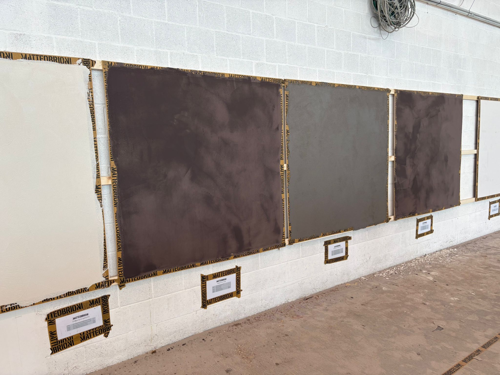 Showroom mit Mikrozement-Musterplatten in fünf Farbtönen – exklusive Materialien Matteo Brioni und HD Surface